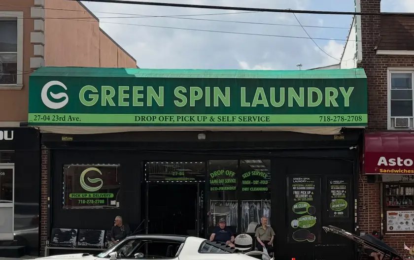 Green Spin Laundry seen from across 23rd Avenue, with its full green sign