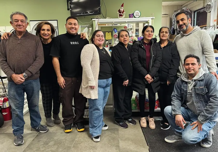 The Green Spin family and team standing together inside the store