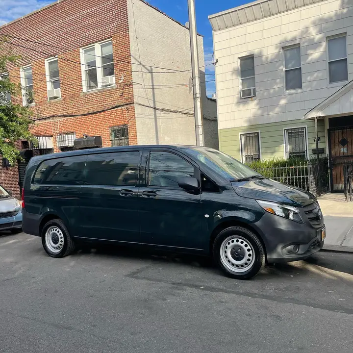 Green Spin's dark green delivery van parked on a residential street in Queens